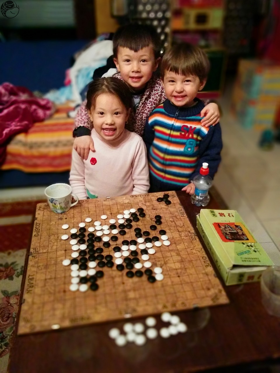 photo of children in front of a weiqi board